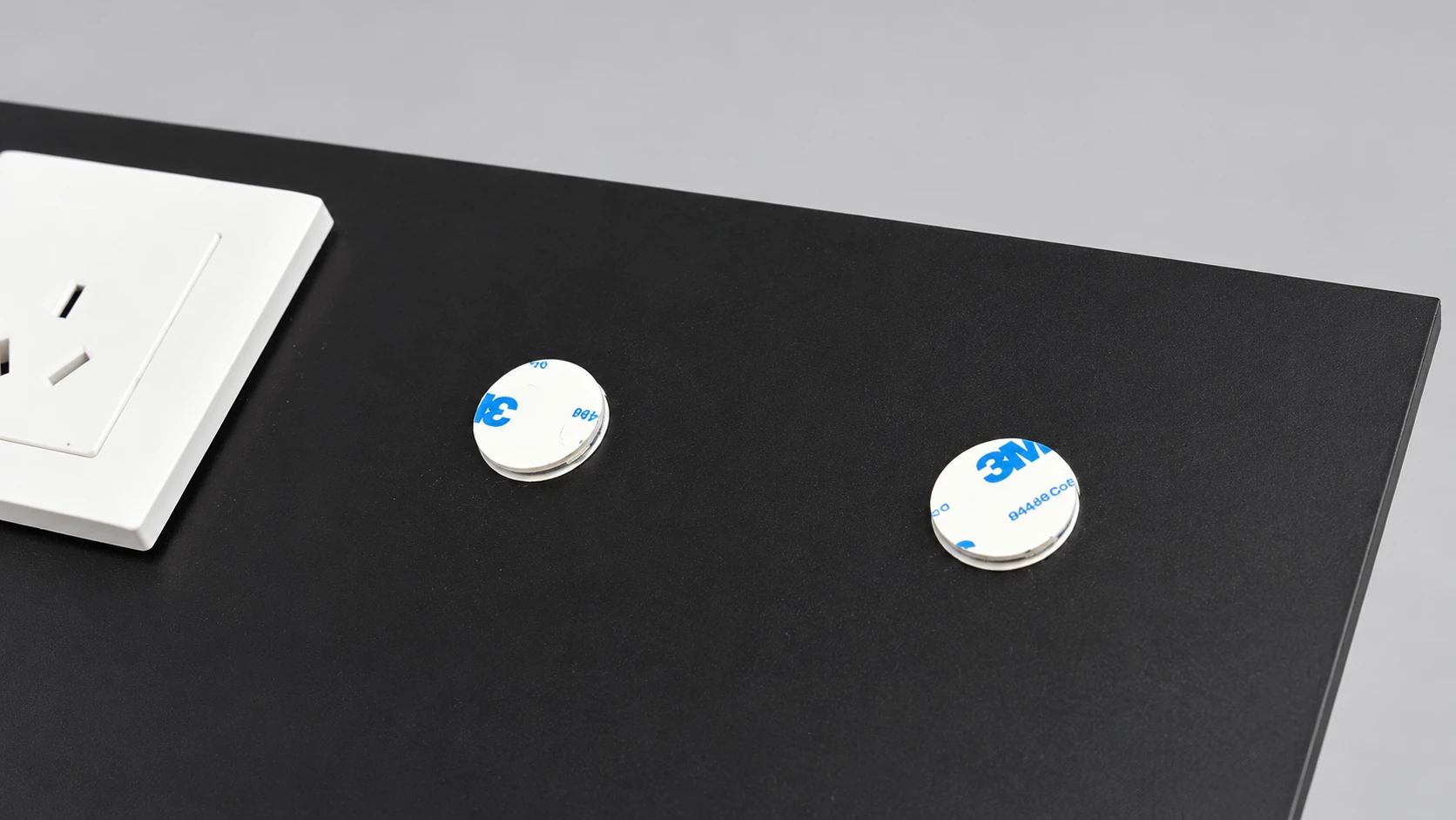 Two round adhesive mounting positions on the black display face